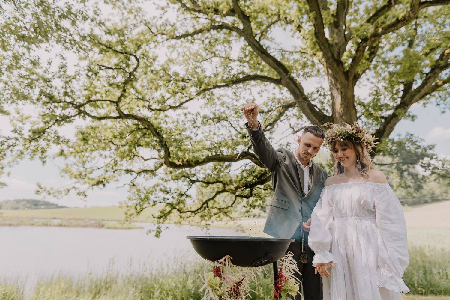 A romantic outdoor ceremony under a blooming tree with natural sunlight filtering through the branches.