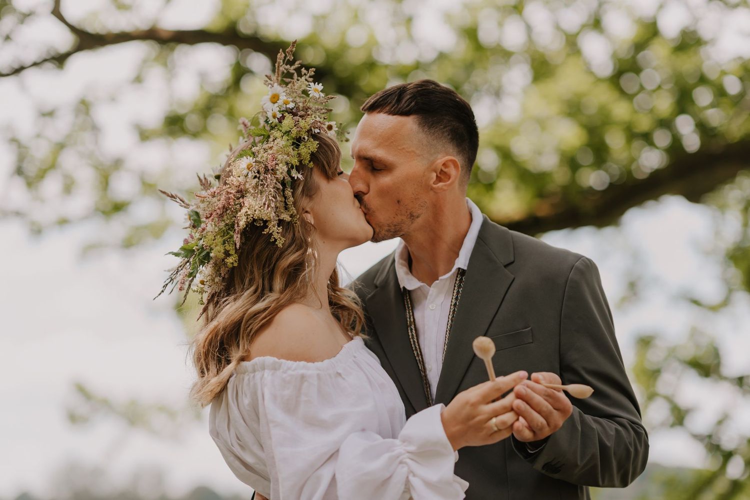 Couple sharing intimate wedding day moments in a sunlit outdoor setting.