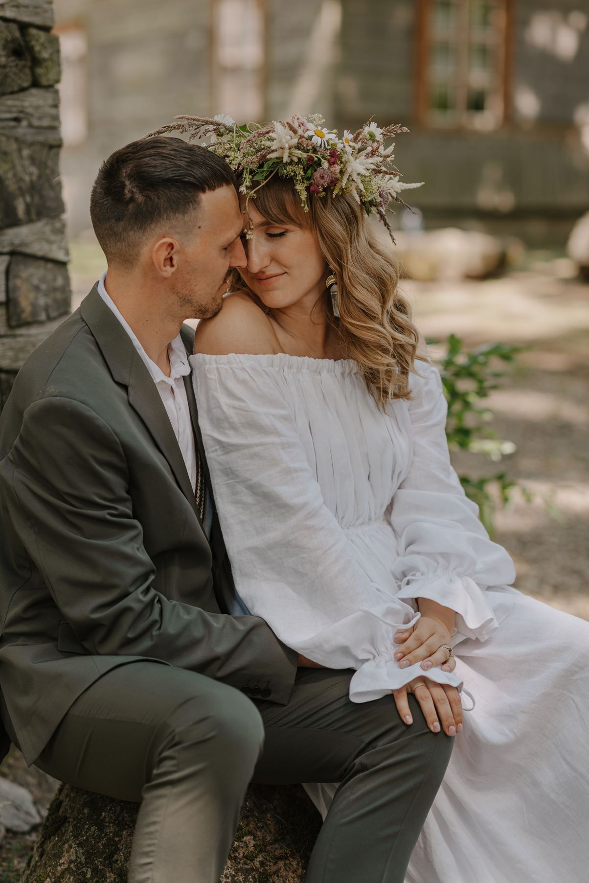 A romantic scene against a stone wall backdrop with natural lighting creating a soft atmosphere.