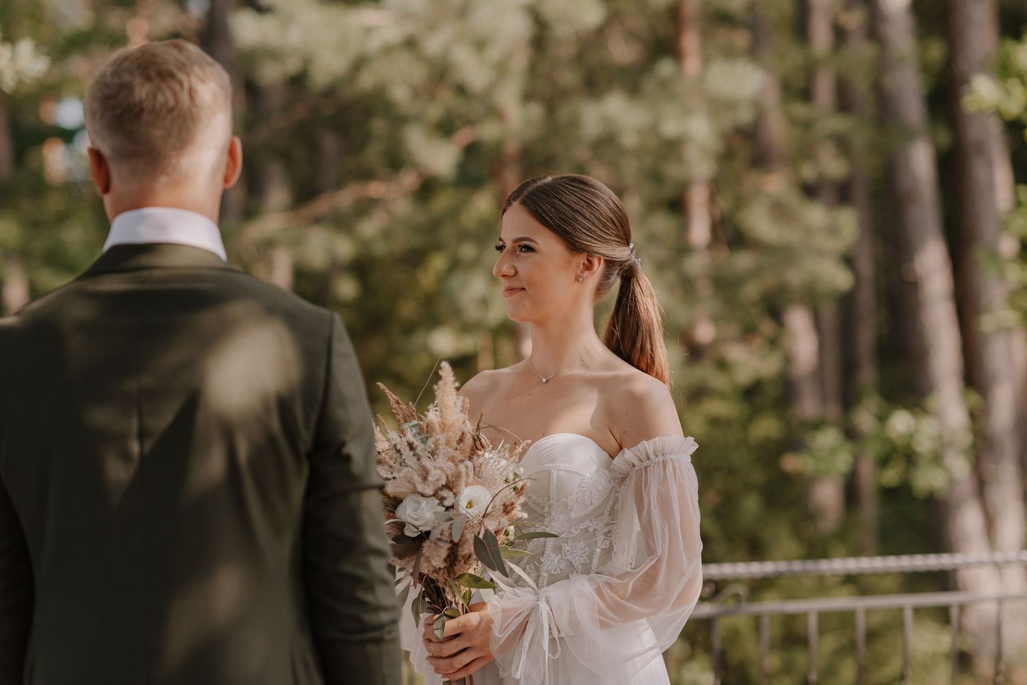 Outdoor wedding ceremony moment captured in natural forest setting.