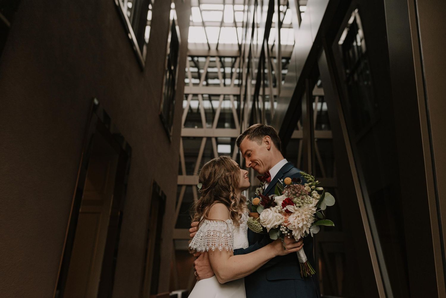 Wedding couple shares intimate dance in dimly lit indoor venue.