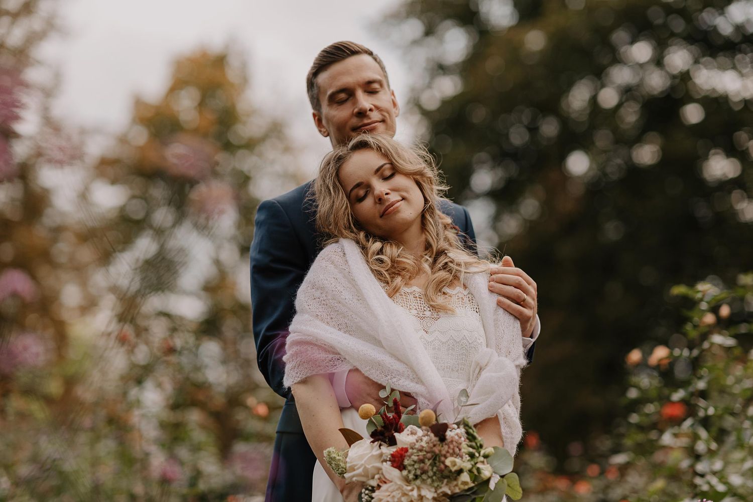 Romantic wedding portraits taken in garden with blooming fall flowers.