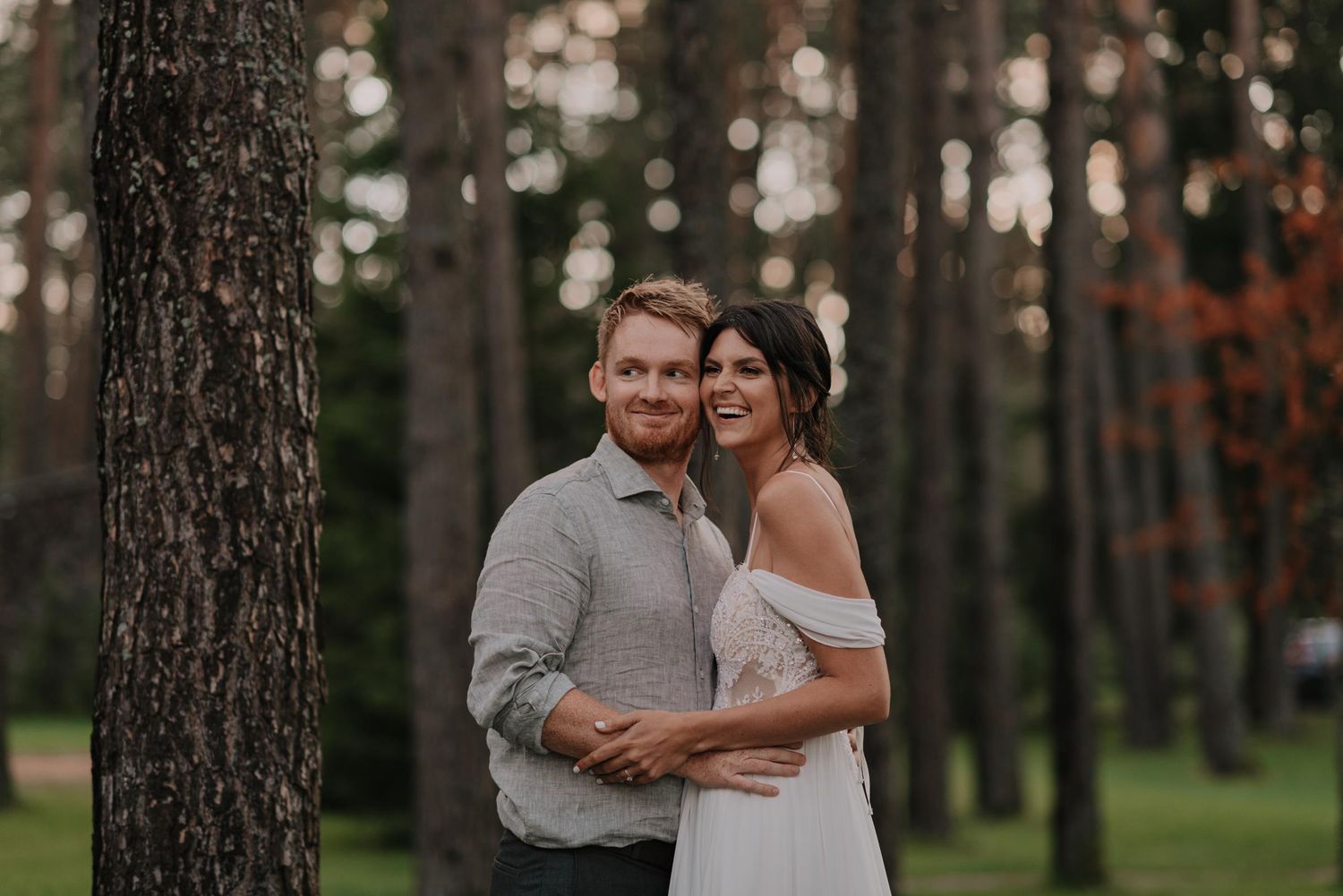 Intimate wedding moment captured in a serene pine forest setting.