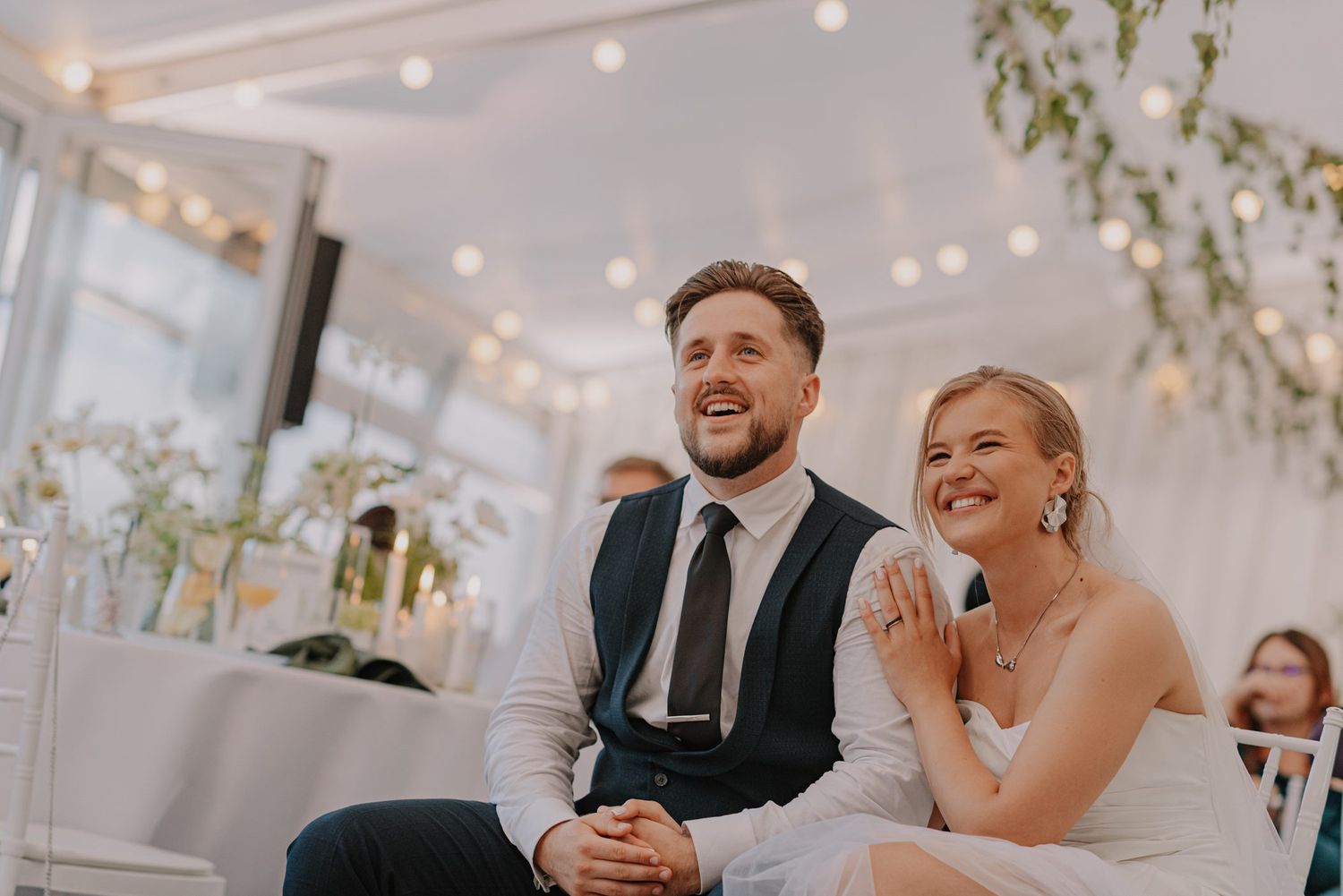 A couple shares a candid laughing moment during their wedding reception.