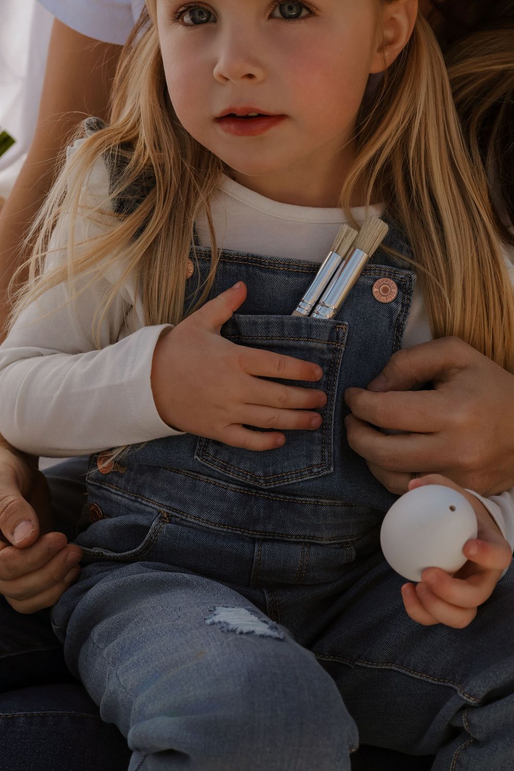 Artistic portrait shots focusing on denim overalls and white sweater details.