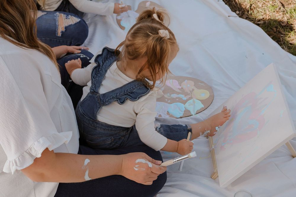 Family members sitting together on white blanket for casual outdoor portraits.