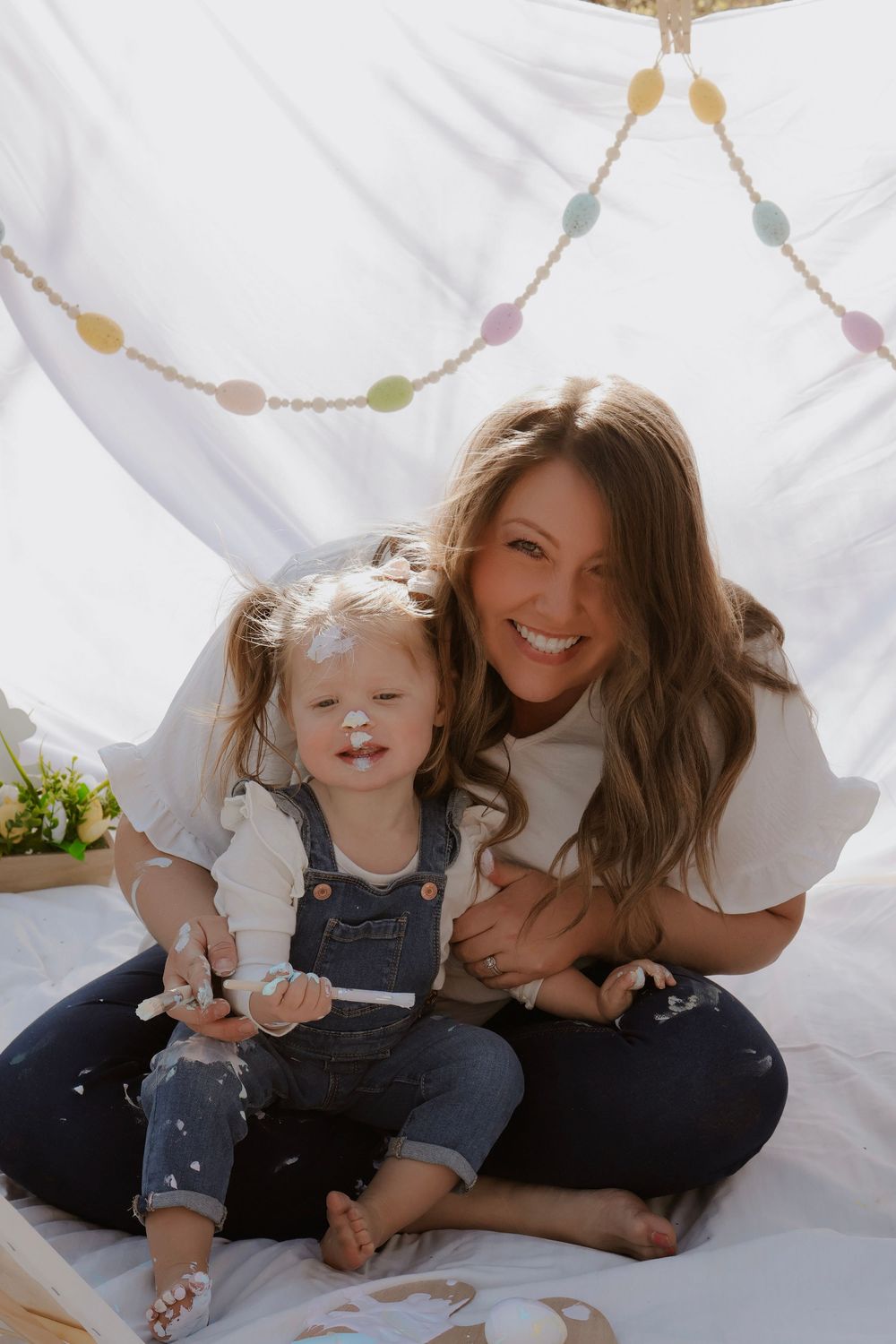 Joyful moment captured on white blanket during outdoor family photoshoot.