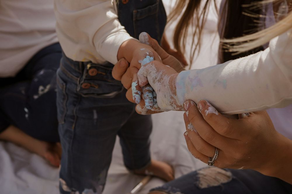 Close-up of hands covered in paint during creative art session.