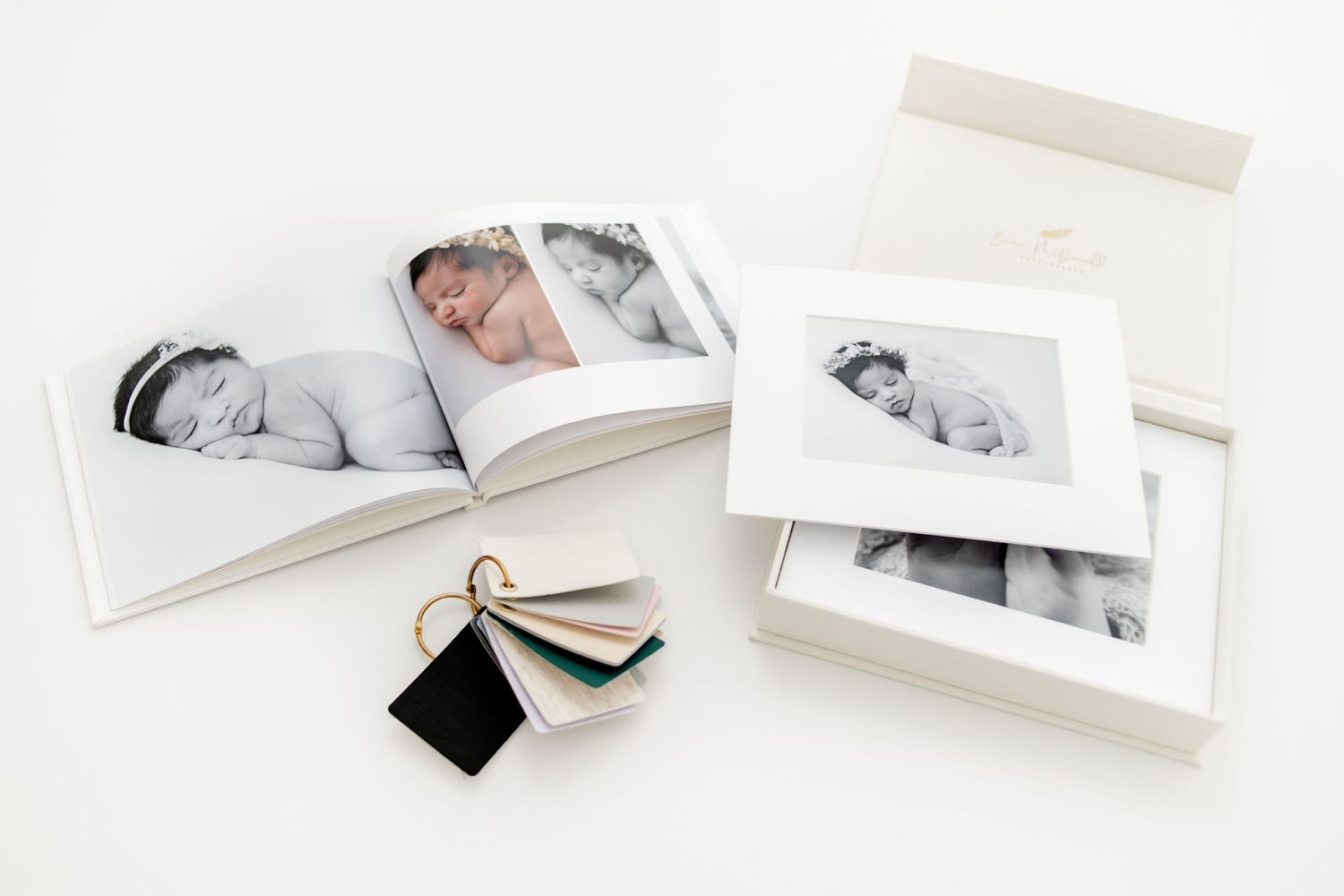 Black and white photo prints and albums displayed with decorative tags on a white surface.