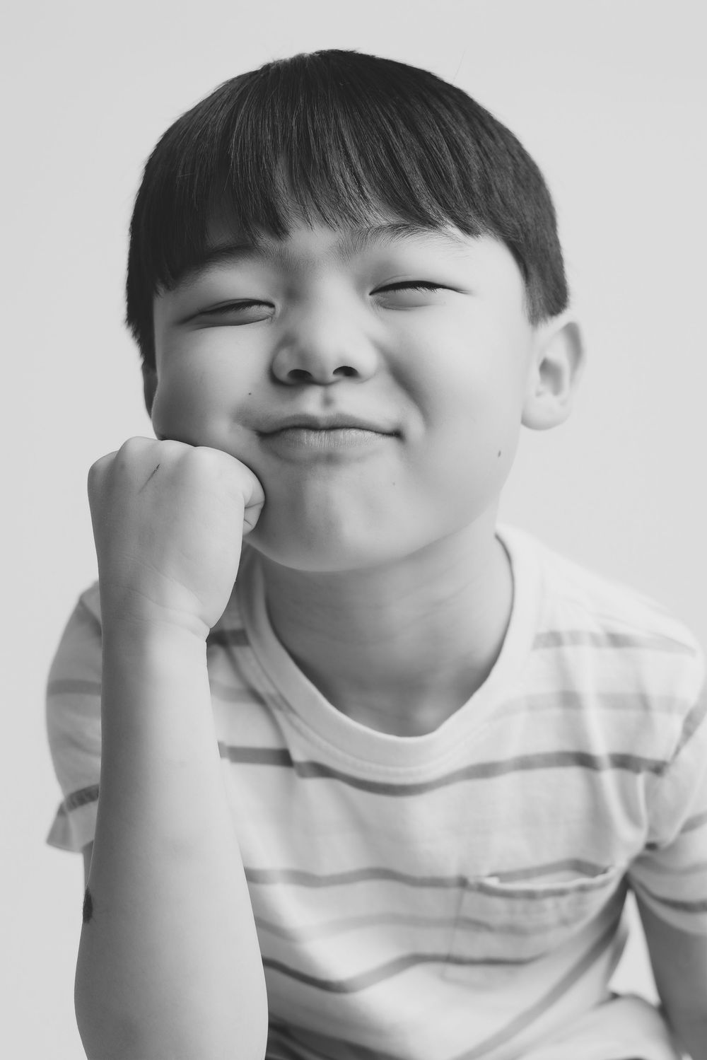 Black and white portrait sequence capturing playful facial expressions and gestures.