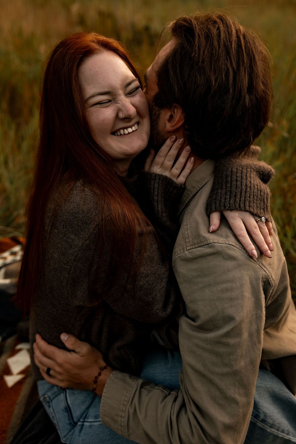 A couple shares intimate moments in a series of candid photos taken outdoors in autumn lighting.