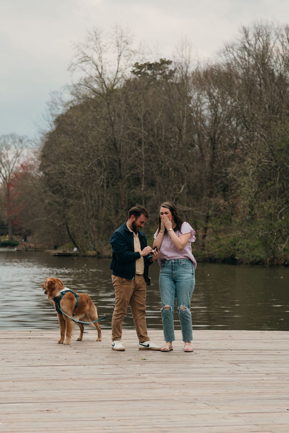 Couple shares surprise proposal on dock with dog during lakeside moment at Piedmont park in Atlanta, ga.