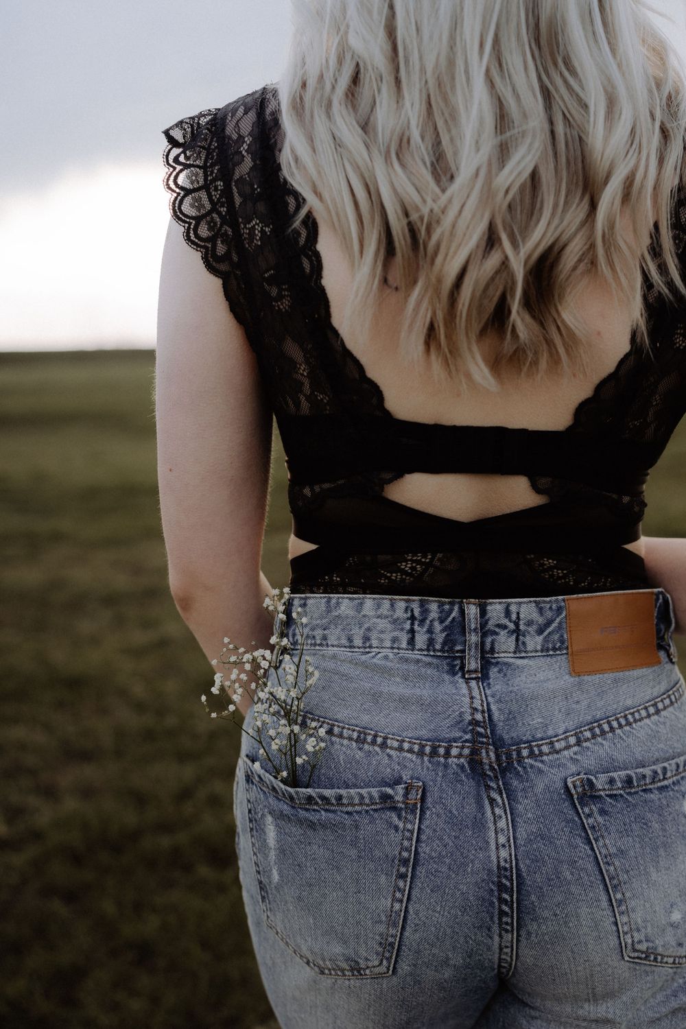 Back view of black lace top and denim with baby's breath flowers.