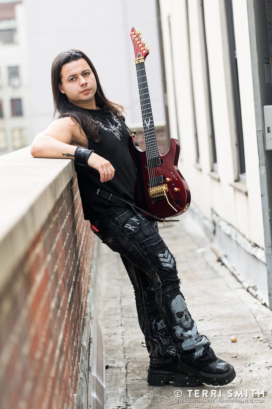 Luís Kalil of Red Devil Vortex posed on a roof top in New York City with his custom, red & black shimmer ESP guitar (Luis Kalil), 2026