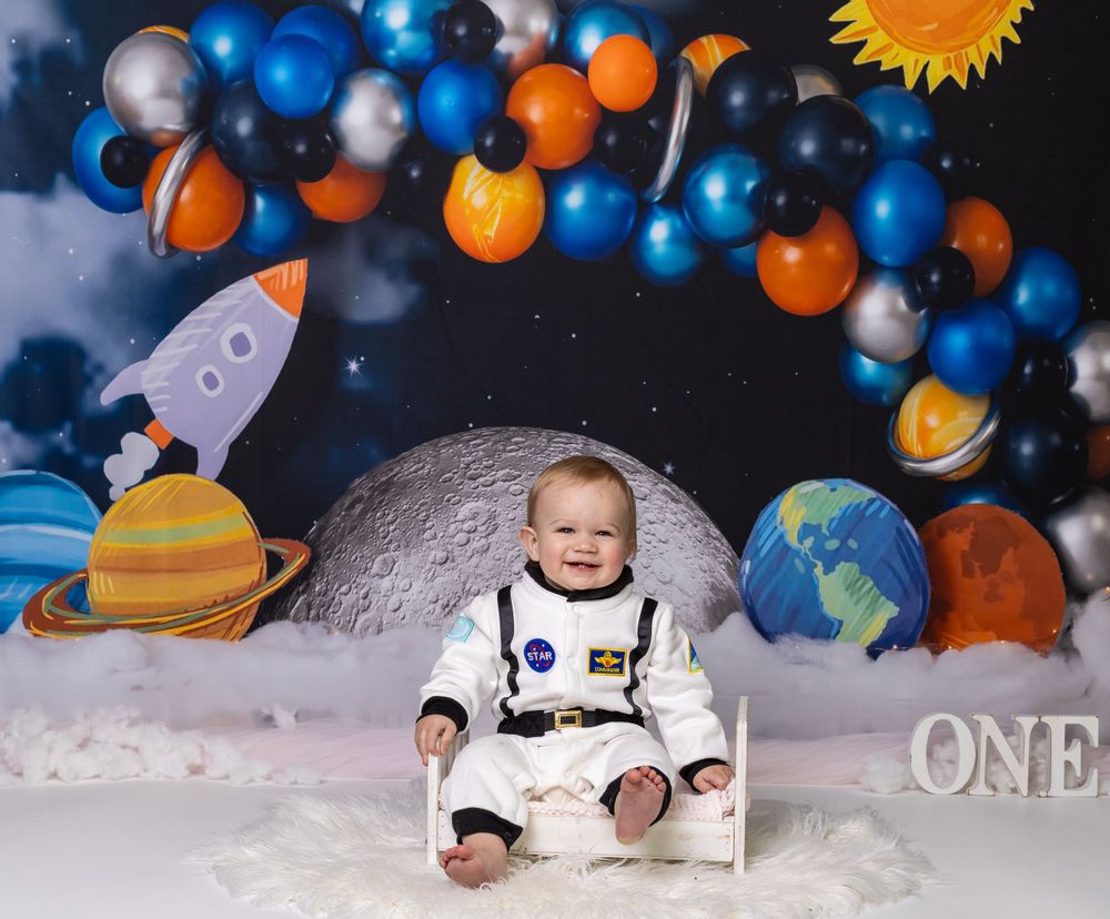 Baby during astronaut-themed cake smash in Glenview IL studio featuring planets, rockets, and space-inspired decor for first birthday