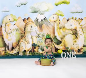 Baby during One-a-Saurus dinosaur-themed cake smash in Glenview IL studio with dinosaur backdrop, greenery, and fun props for first birthday