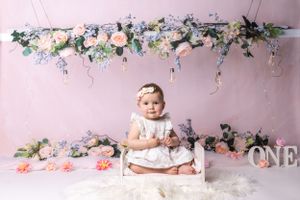 Baby during boho-themed cake smash in Glenview IL studio featuring soft floral decor, pastel tones, and elegant setup for first birthday.