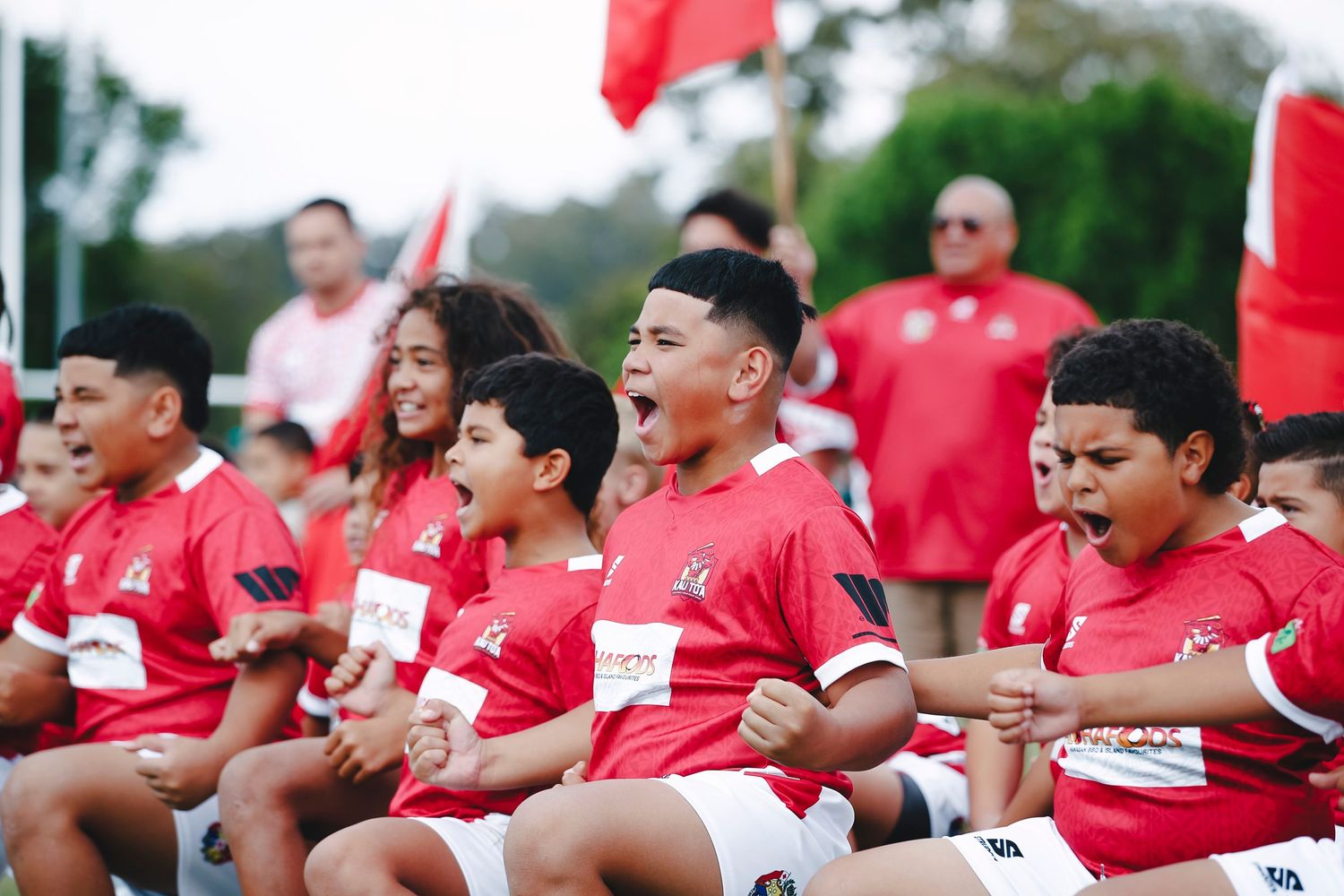 Team in red uniforms cheering enthusiastically from sideline benches.