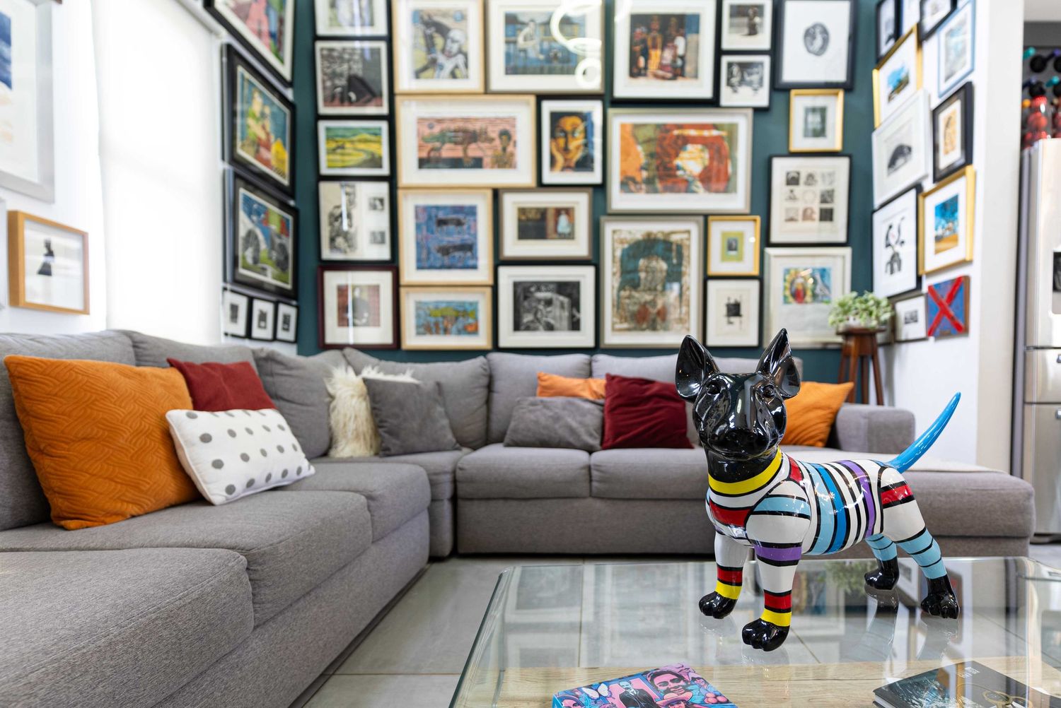 Luxury living room with modern decor, gallery-style wall art, and a cozy seating area.