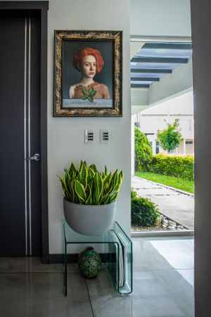 Entrance hallway featuring a statement artwork, modern lighting, and indoor plants