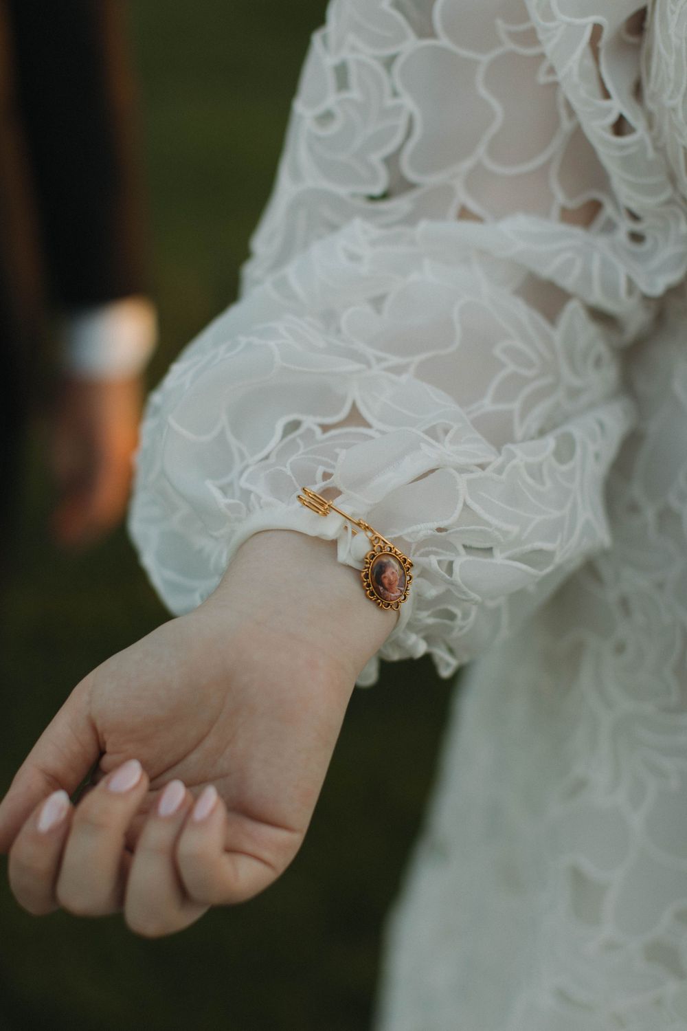 Close-up of delicate lace sleeve detail and bracelet on a wedding dress.