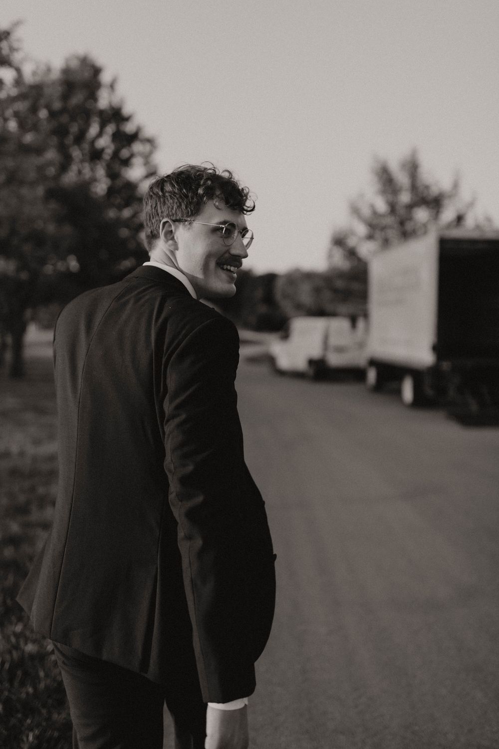 A series of black and white photos showing a person in a suit walking away on an outdoor path.