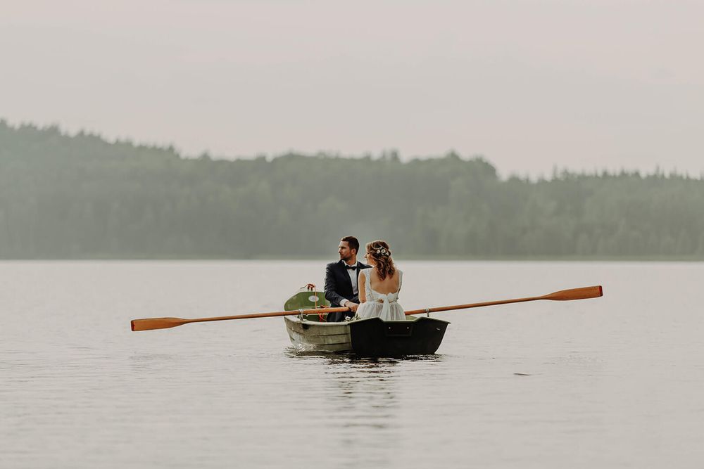 Romantic couple rowing a small wooden boat across a misty lake in Leitrim.