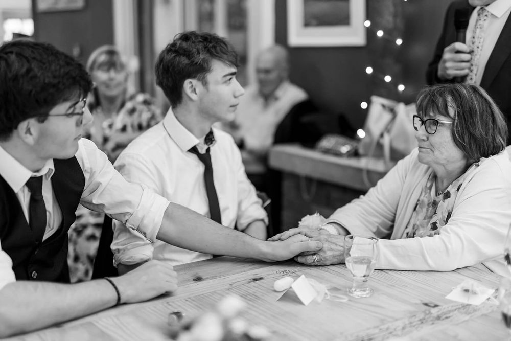 Casual gathering of wedding guests engaged in conversation at a table.