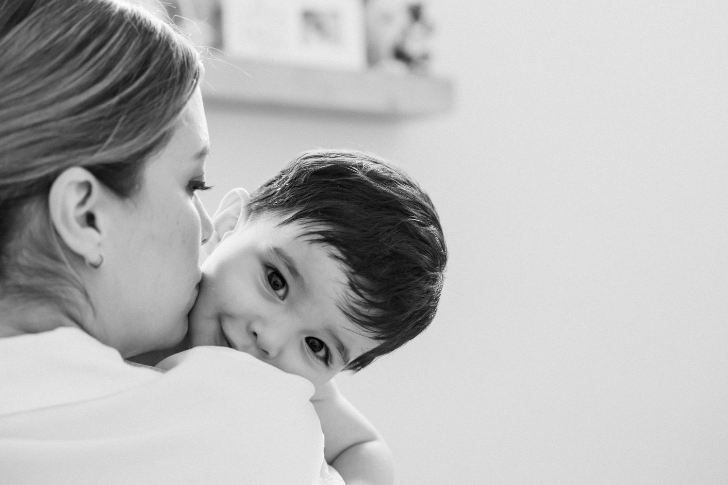 Intimate black and white portrait of parent and child sharing a tender moment.