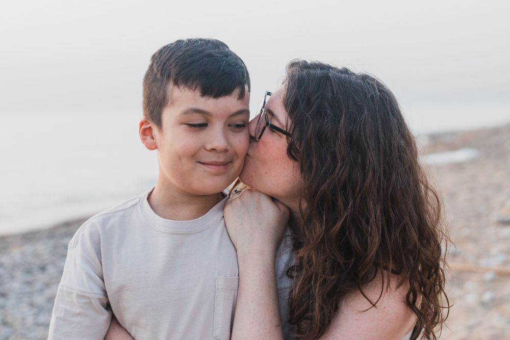 An intimate moment captured between parent and child at the beach.