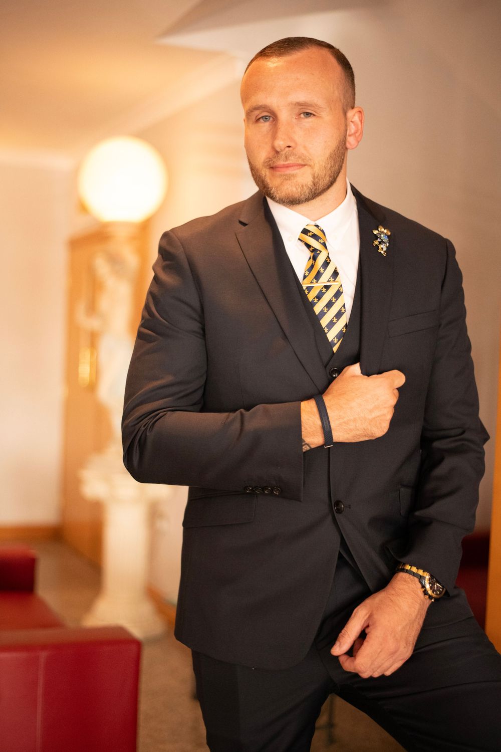 A formal portrait of a man wearing a dark suit with striped tie.