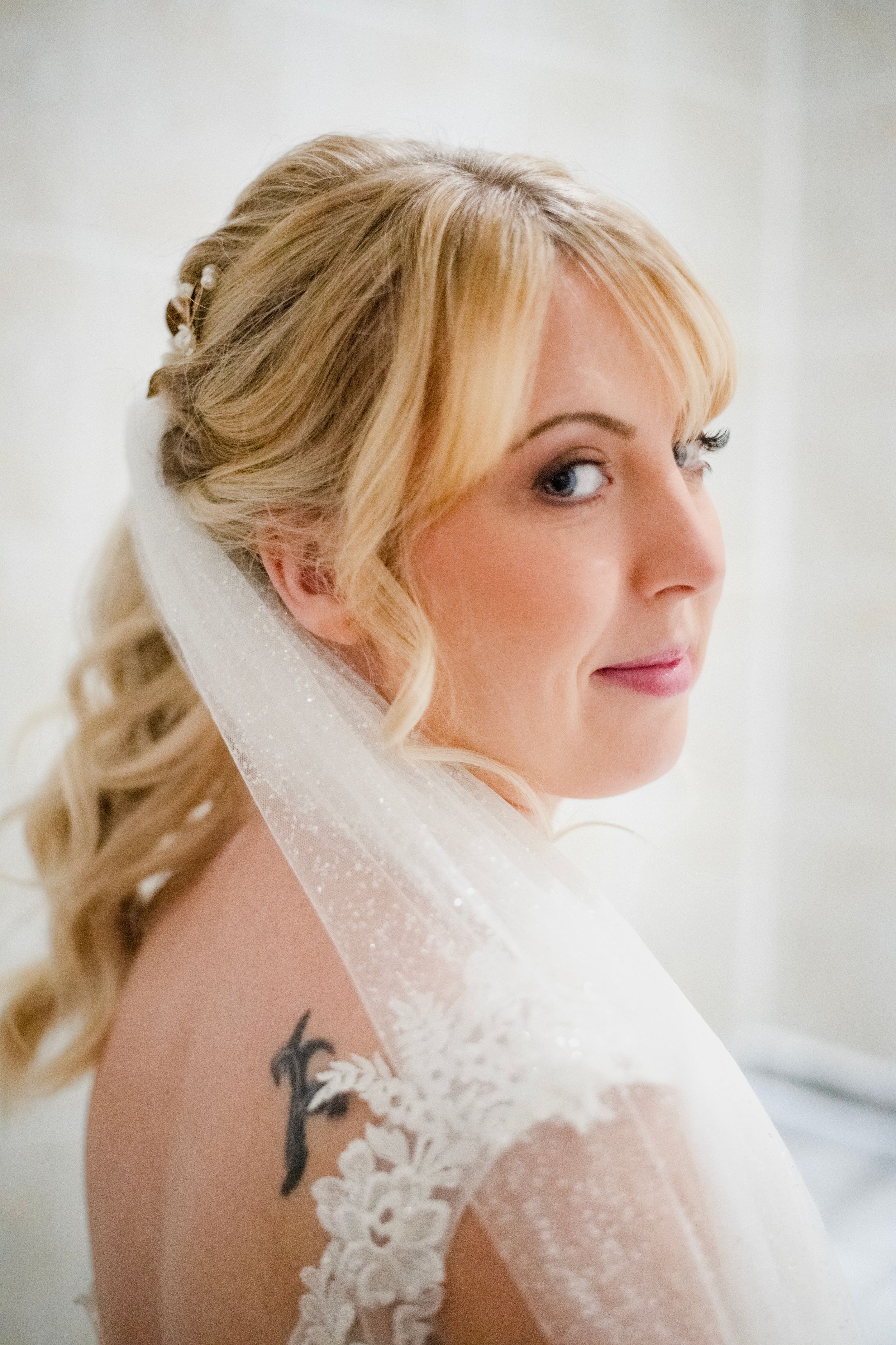 Bridal portrait showcasing elegant hair styling and a delicate lace veil.