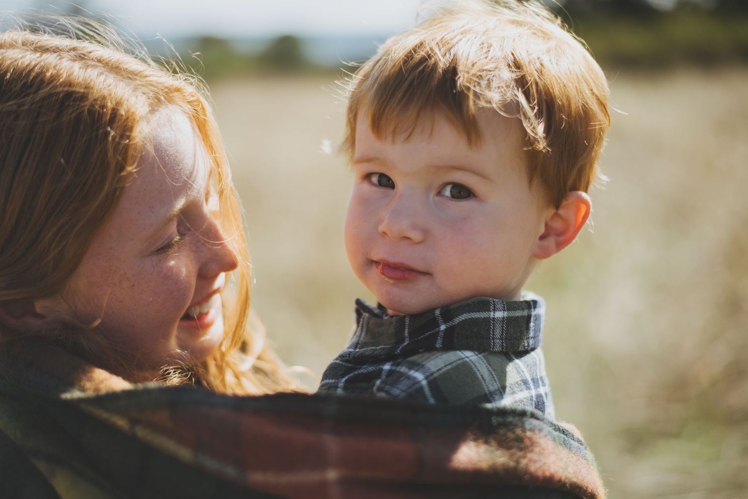 Candid moment captured in warm sunlight amid golden field.