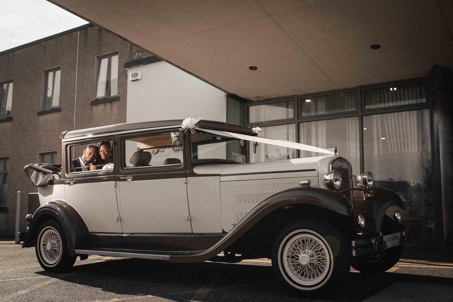 Vintage white classic car from 1930s parked outside building in monochrome.