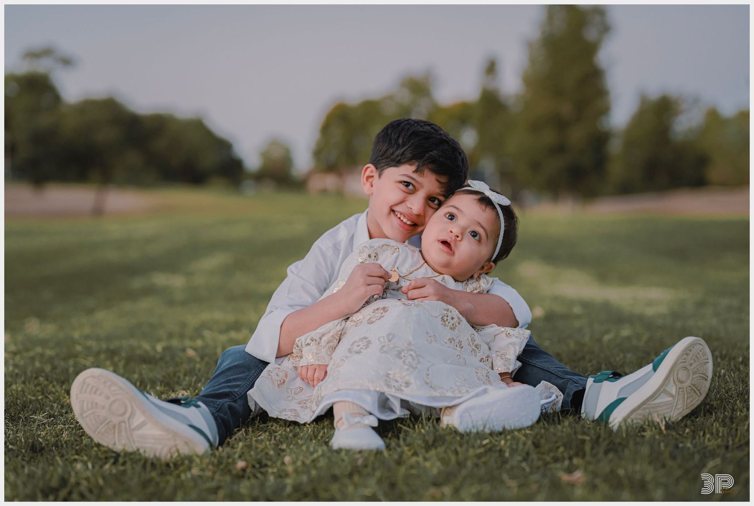 Family of four posing together in a professional studio, with soft lighting highlighting their warm smiles and close bond