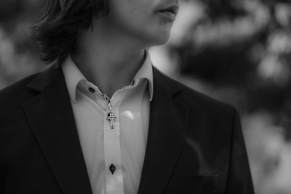 Close-up monochrome photo showing collar and lapel of white dress shirt and dark suit jacket.