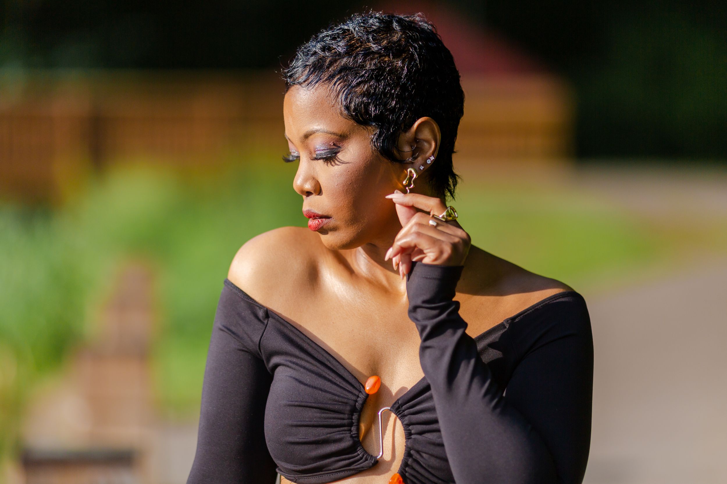 Woman posing in a black outfit during an outdoor portrait session.