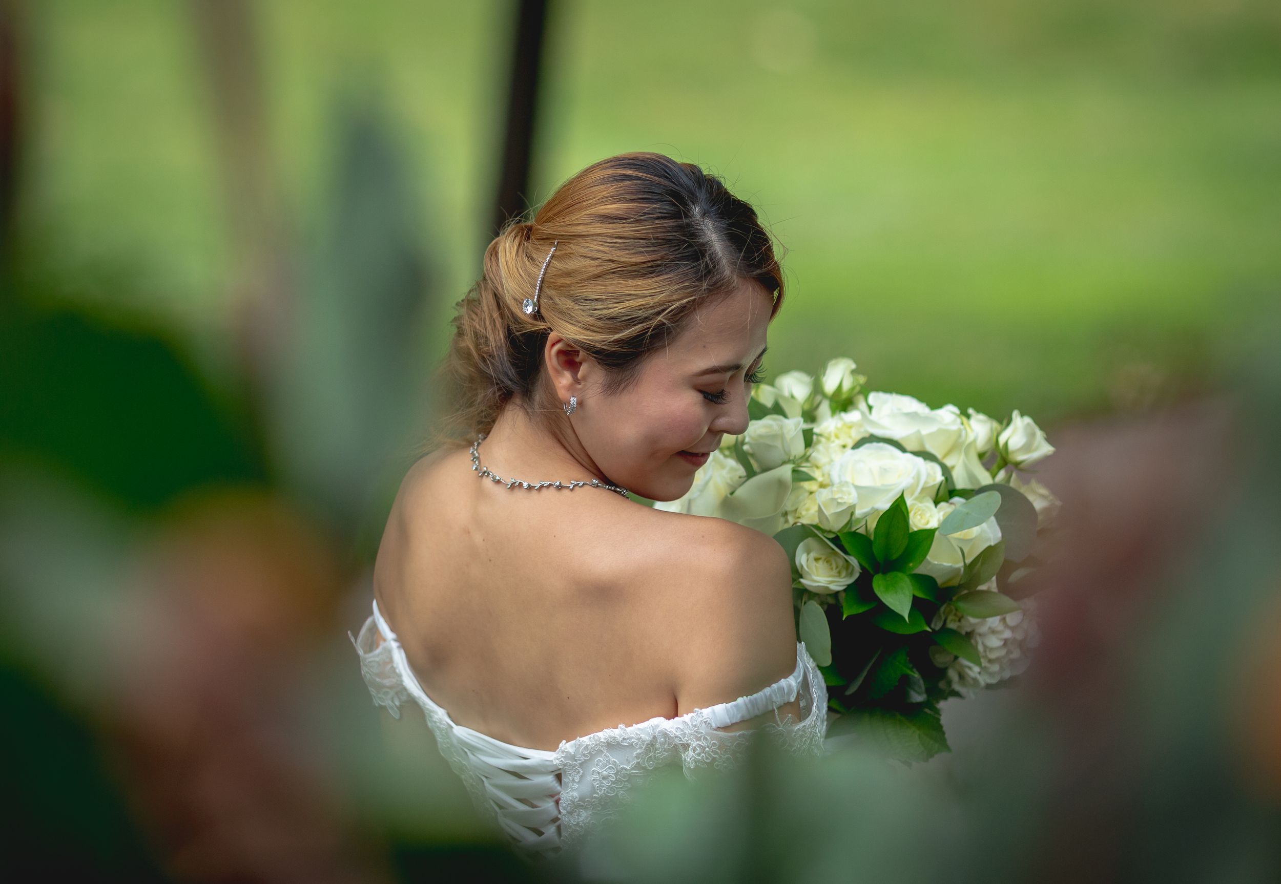 Bride holding a bouquet of white flowers during a romantic wedding portrait session.