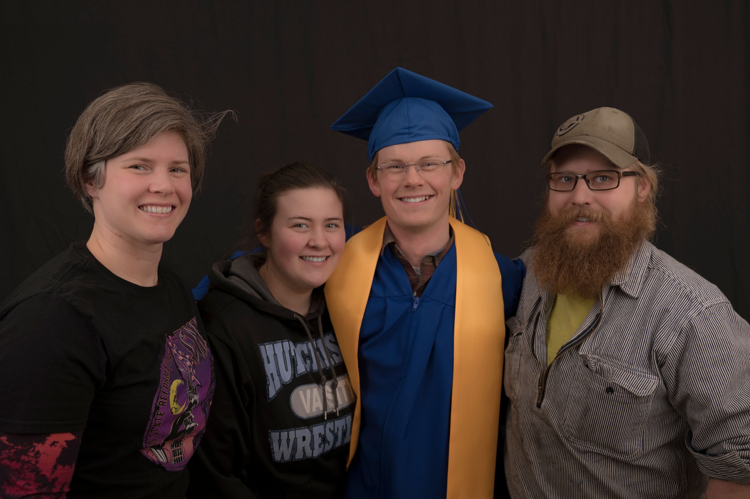 Studio family portrait with recent graduate in the center.