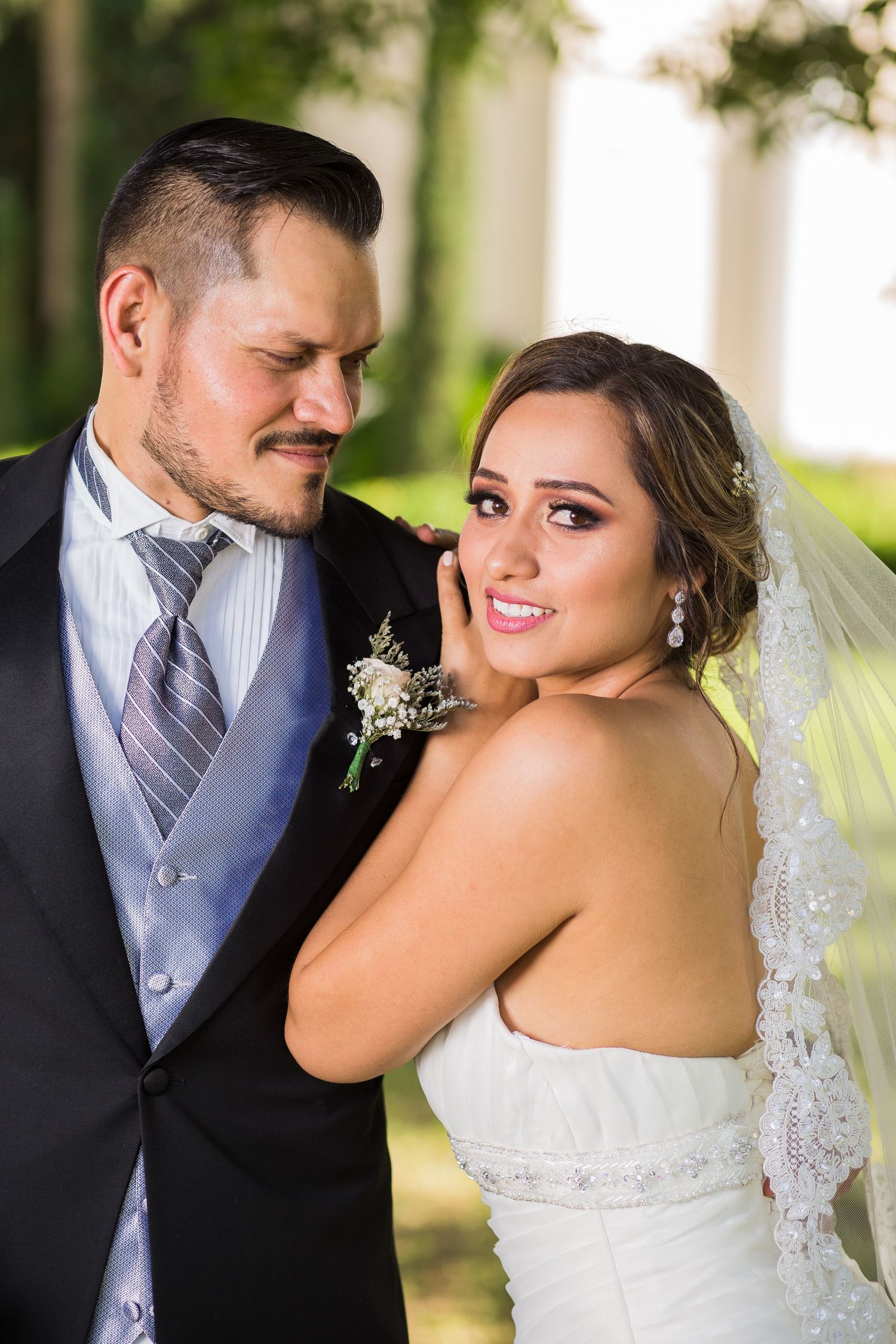 A romantic wedding portrait captured outdoors with natural lighting and elegant formal attire.