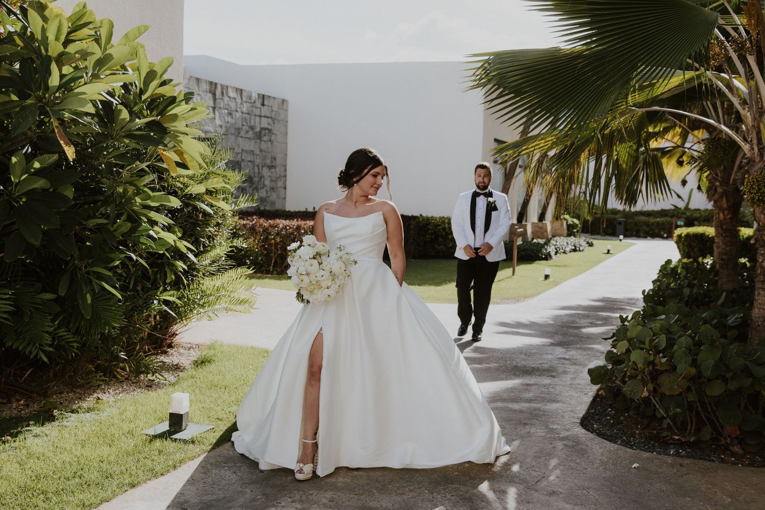 A stunning bridal portrait on a garden path with tropical landscaping.