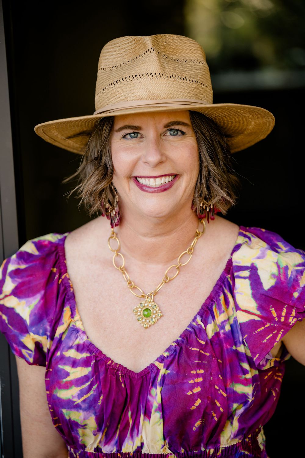 A series of three portrait shots showing a person in a purple floral dress and straw hat against a dark background.