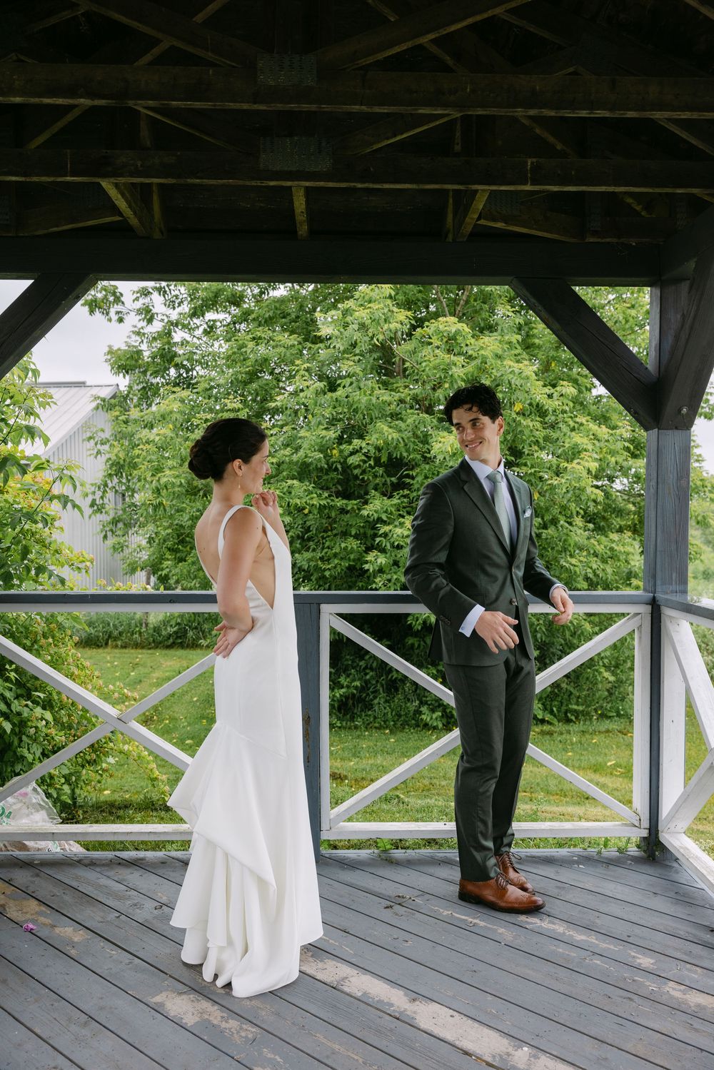Sequence of romantic first look photos on a wooden gazebo deck with lush green trees in background.