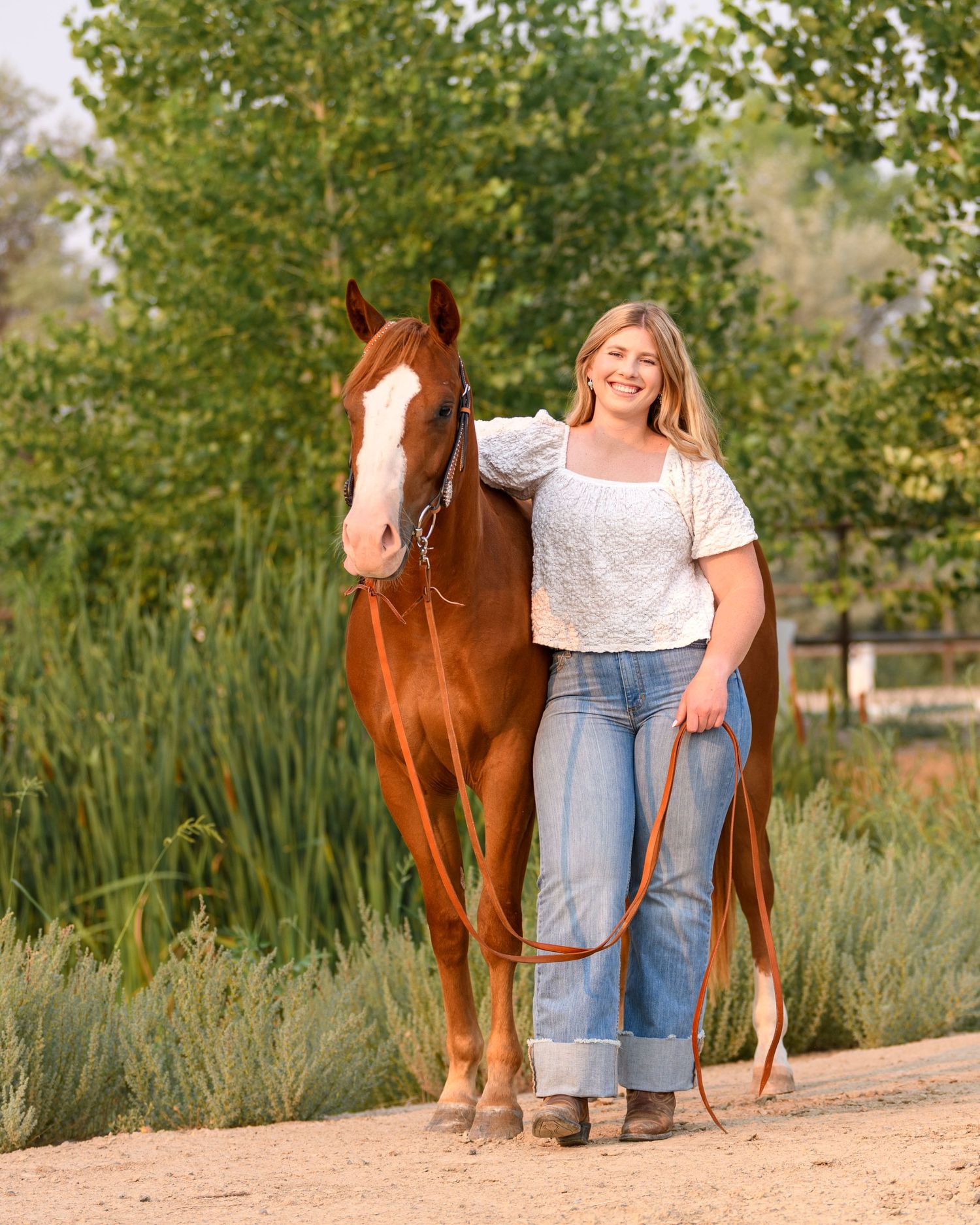 Grace leading Boone through tall grass at sunset in Colorado
