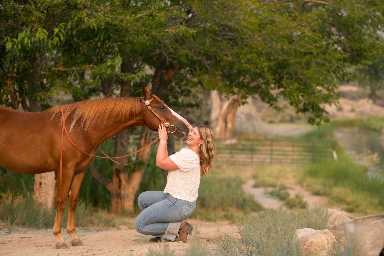 Grace smiling next to her chestnut gelding in western lifestyle portraits