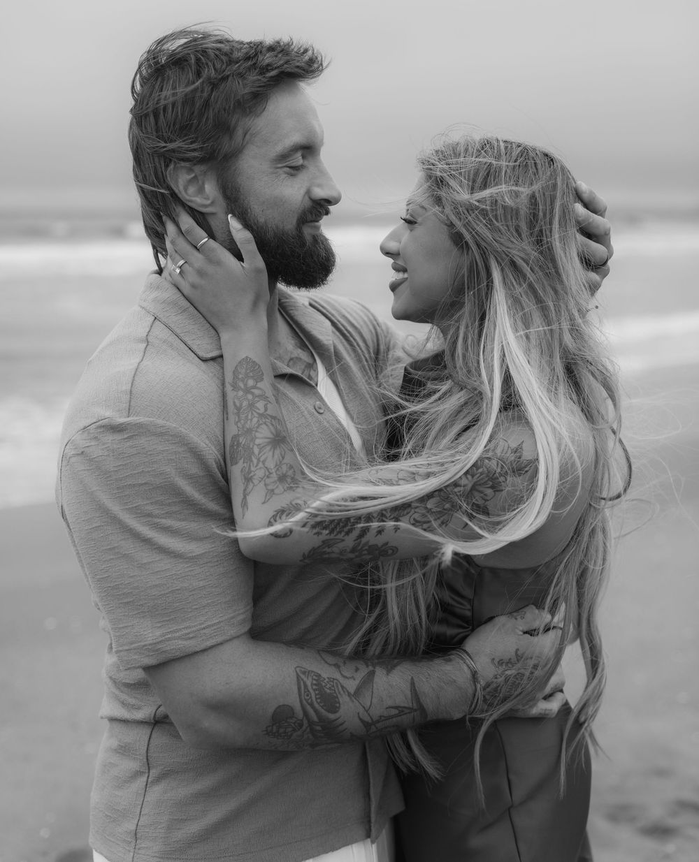 Series of candid romantic beach photos showing couple embracing with wind-blown hair.