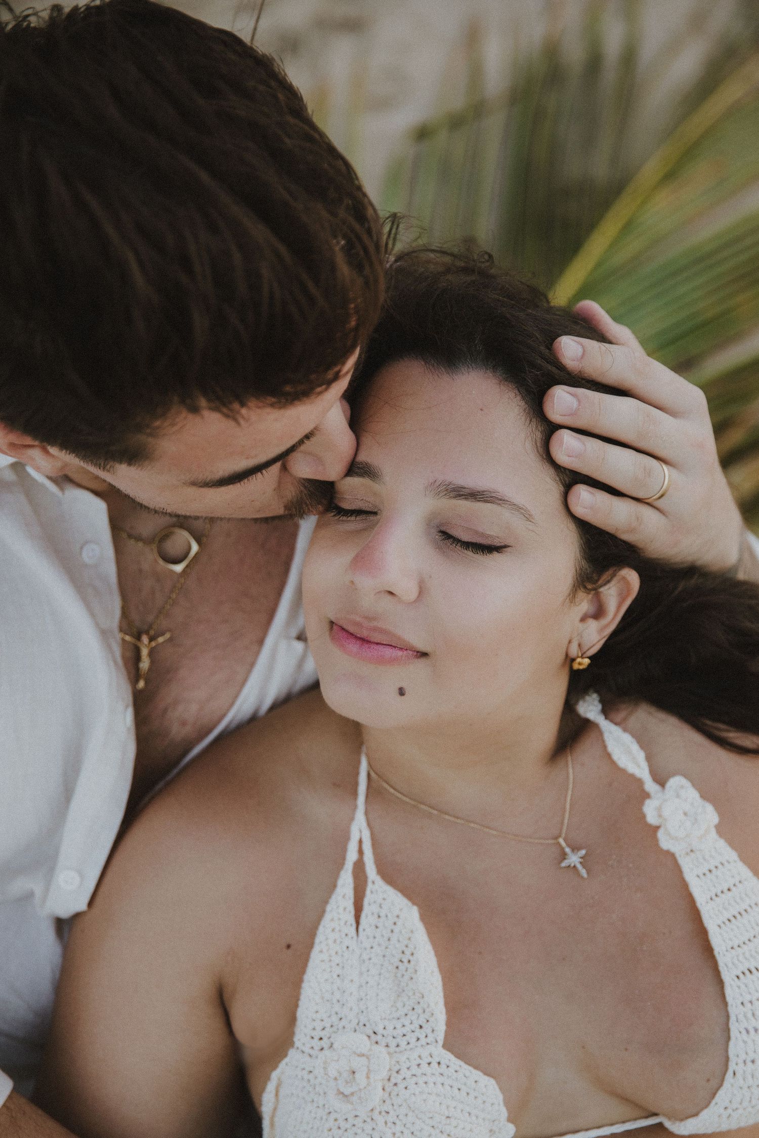Intimate close-up portraits capturing tender moments on beach.