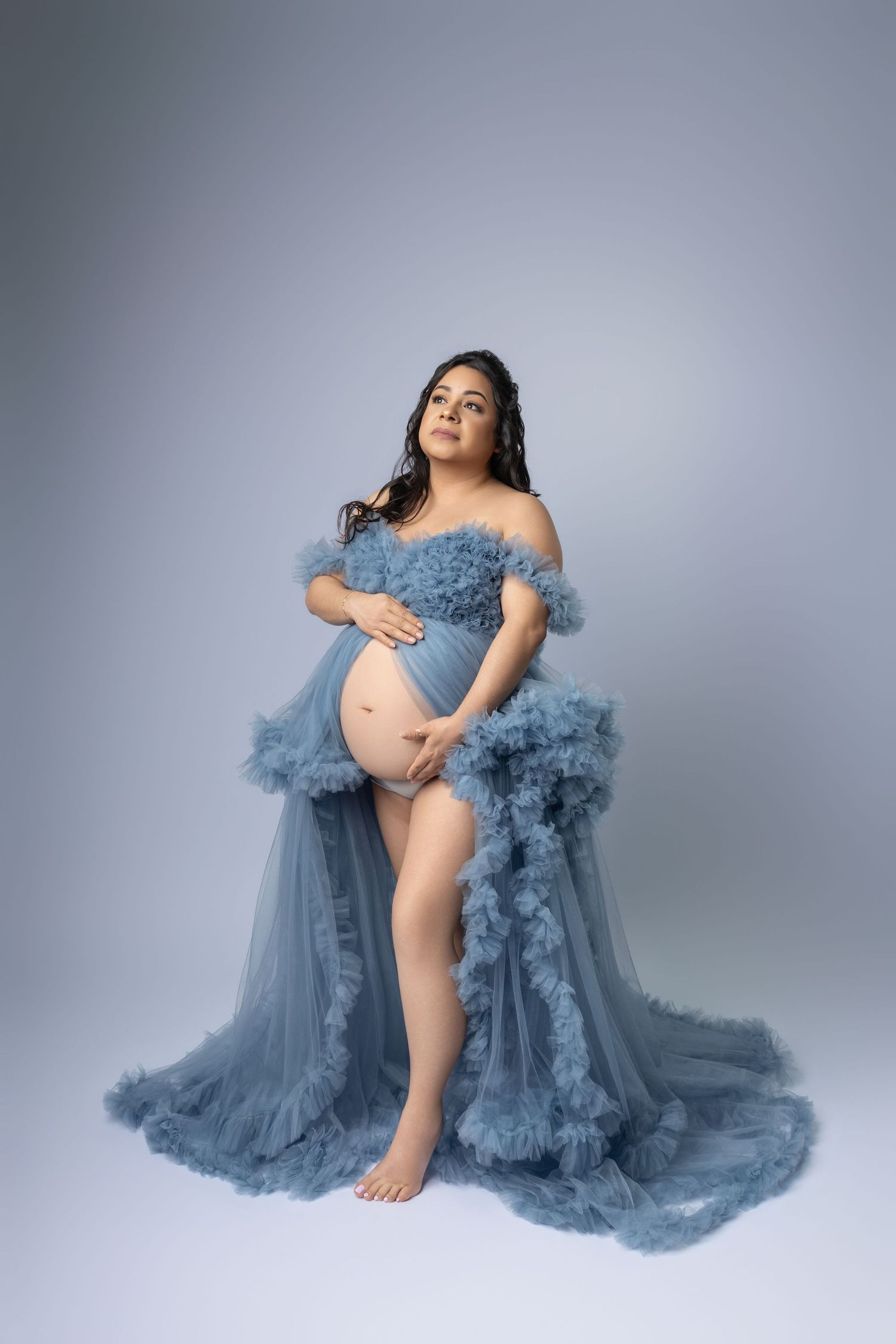 A couple in formal attire poses romantically across three frames, with the woman wearing a flowing navy blue tulle gown.