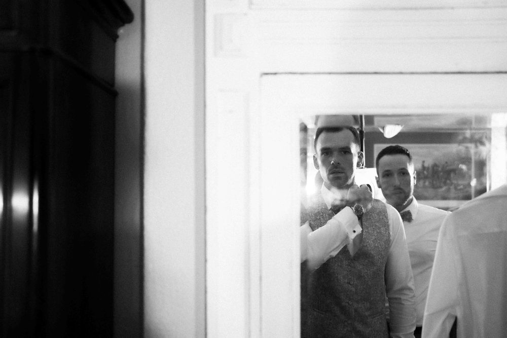 Wedding party preparations reflected in mirror with clean white background.
