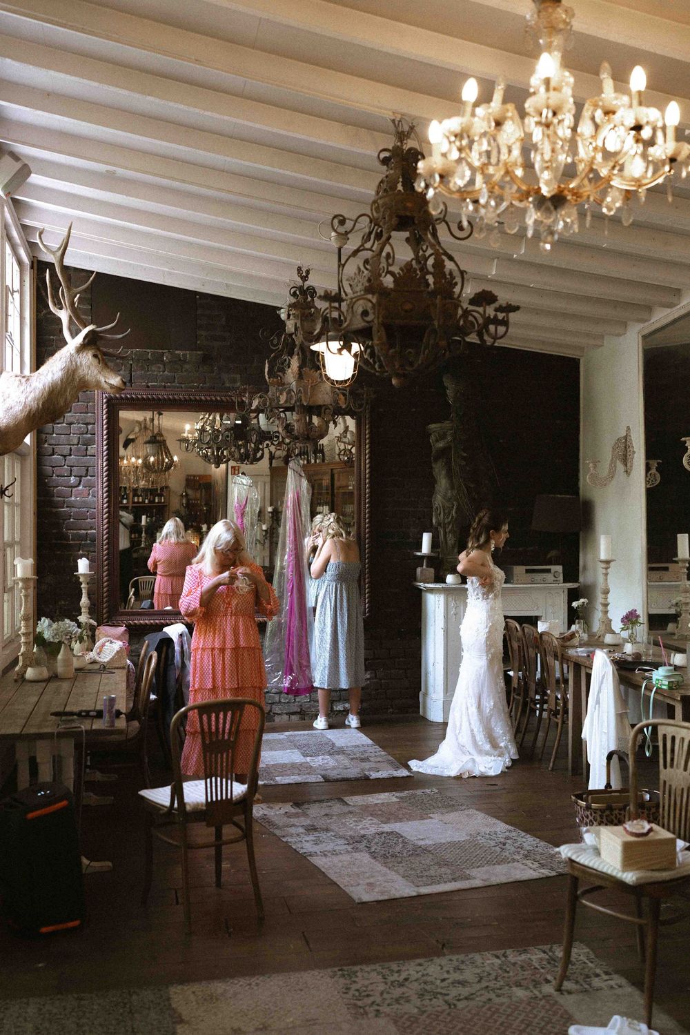 Spacious vintage bridal boutique interior with chandeliers and wedding dresses on display.